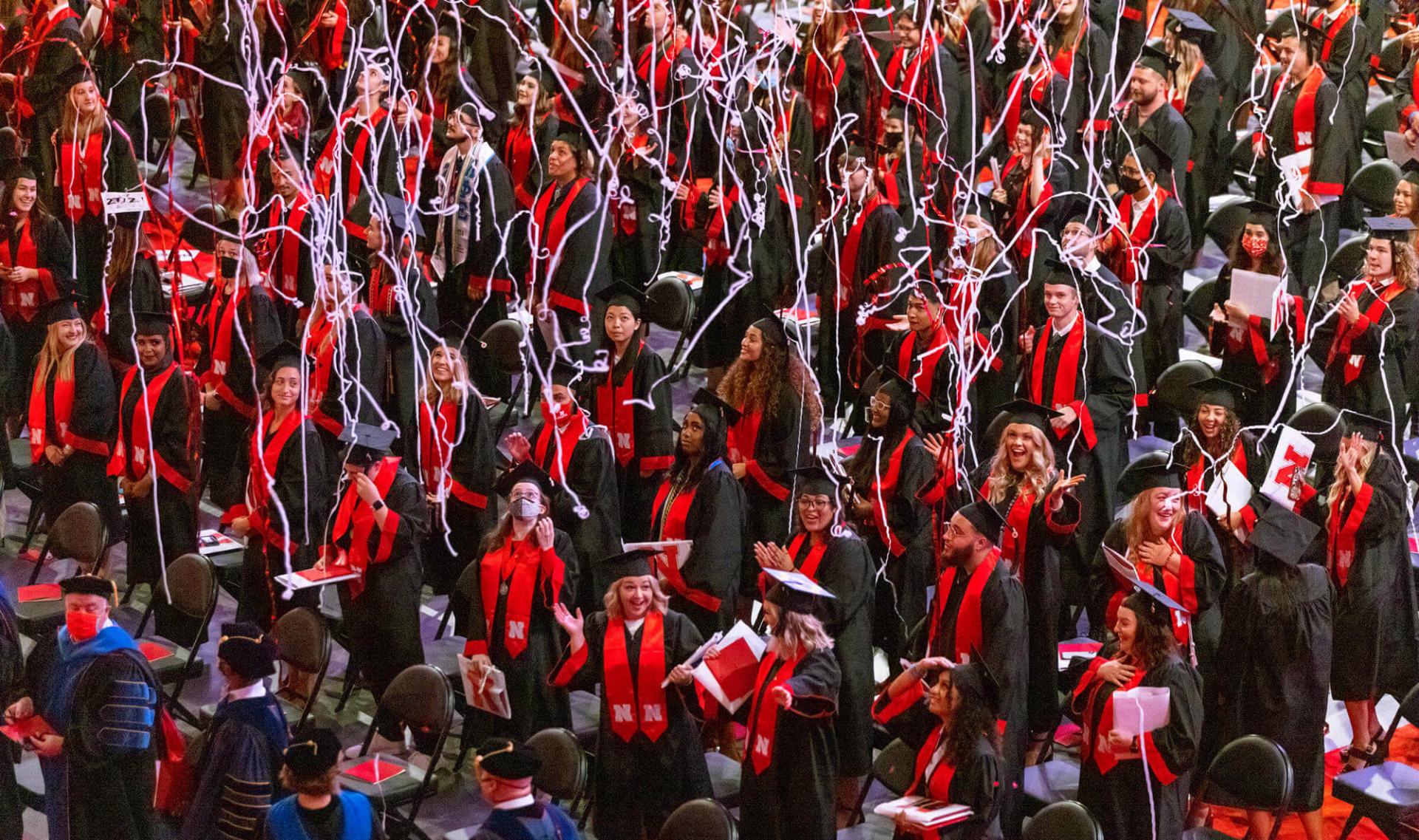 Students standing in Pinnacle Bank arena during commencement