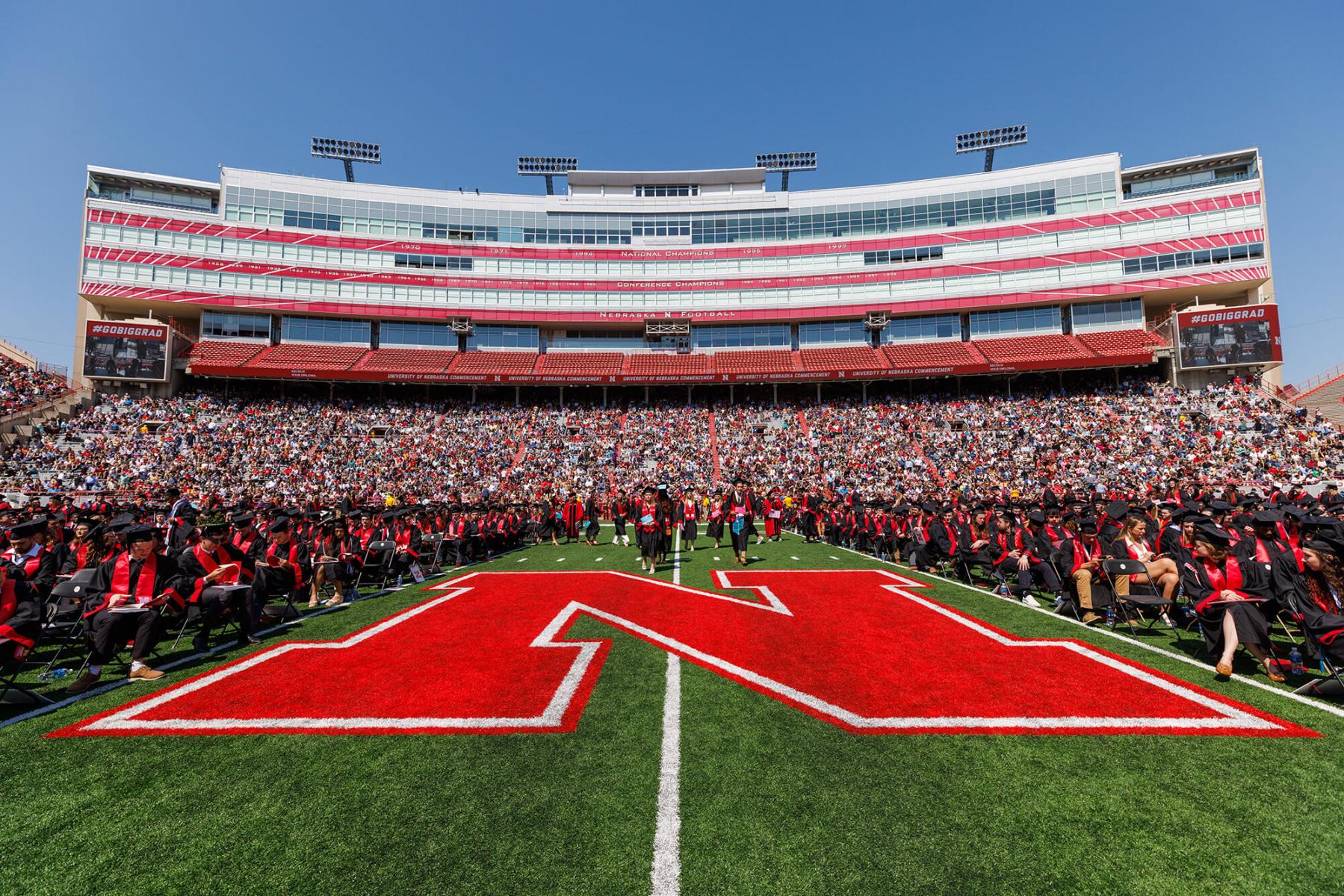 Students seated on field during commencement in Memorial Stadium