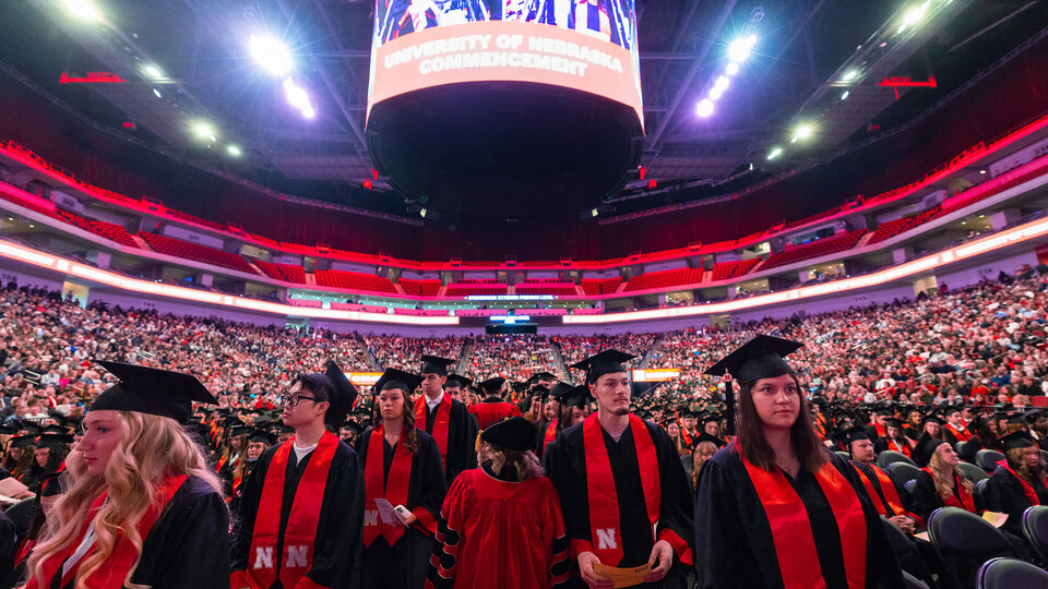 Students facing stage during December 2025 commencement at Pinnacle Bank Arena