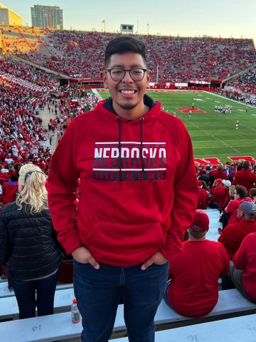 Student smiling for portrait in stands of Memorial Stadium