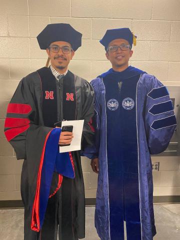 Professor standing with graduate student