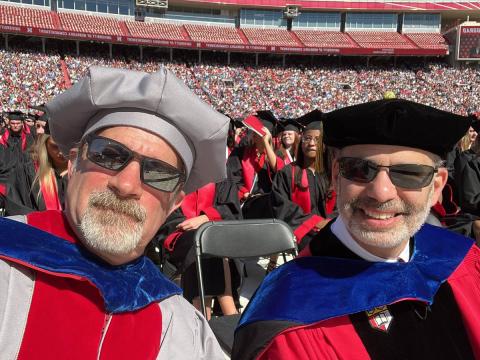 Professors taking selfie together in stadium